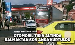 Otomobil tırın altında kalmaktan son anda kurtuldu